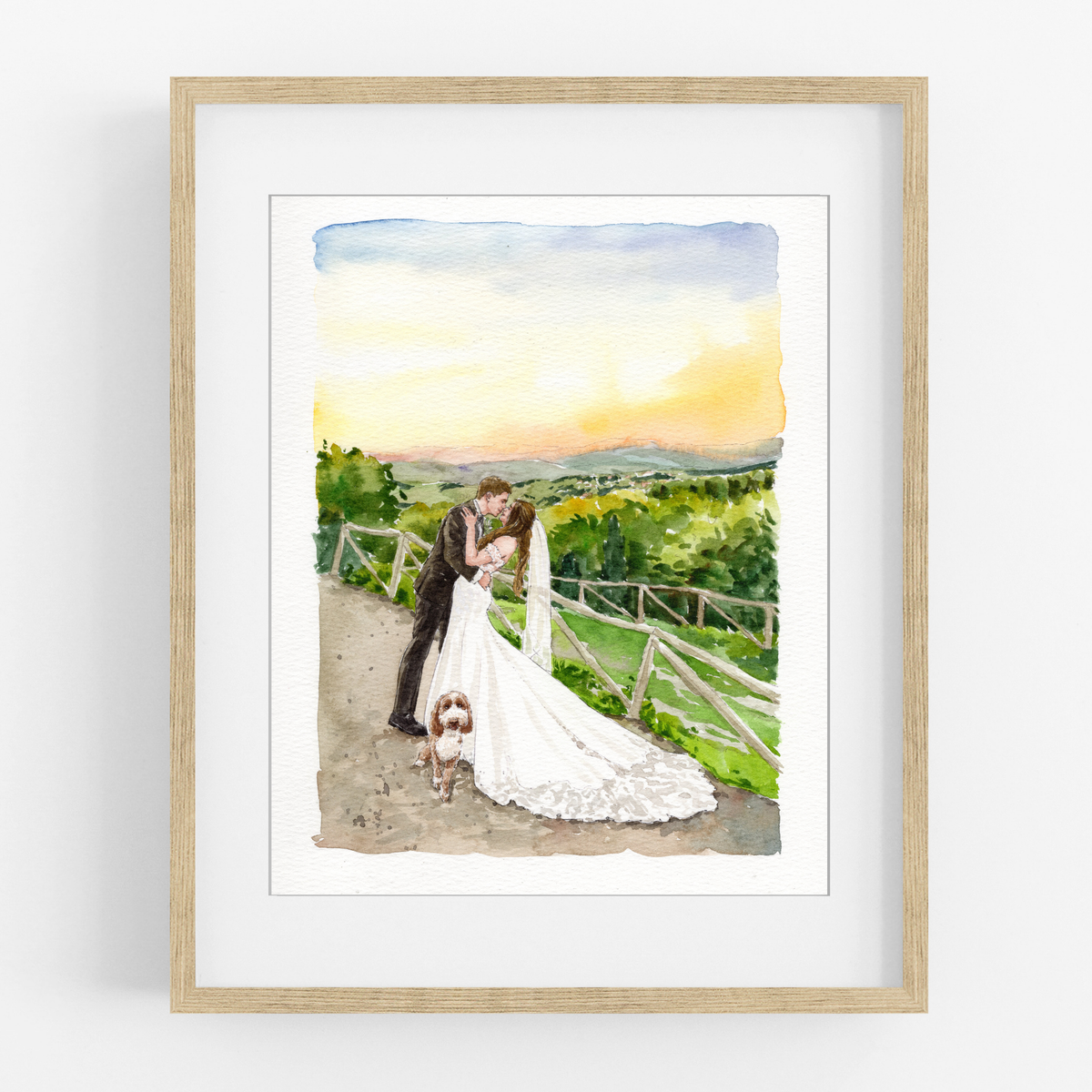 Framed watercolor wedding portrait of a couple beside a railing overlooking green hills at sunset.