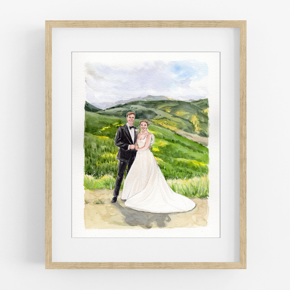Framed watercolor portrait of a bride and groom embracing in a green mountain landscape.