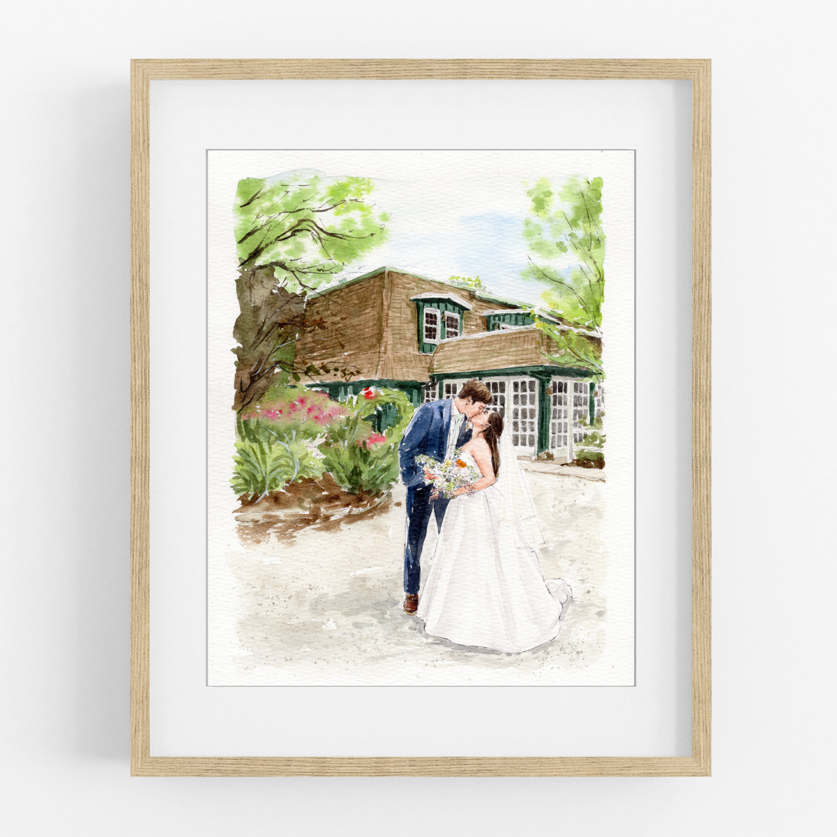 Framed watercolor wedding portrait of a couple standing outside a rustic stone building beneath a leafy tree.