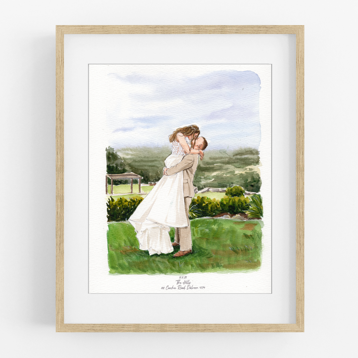 Framed watercolor wedding portrait of a groom lifting his bride in a green garden overlooking distant hills.