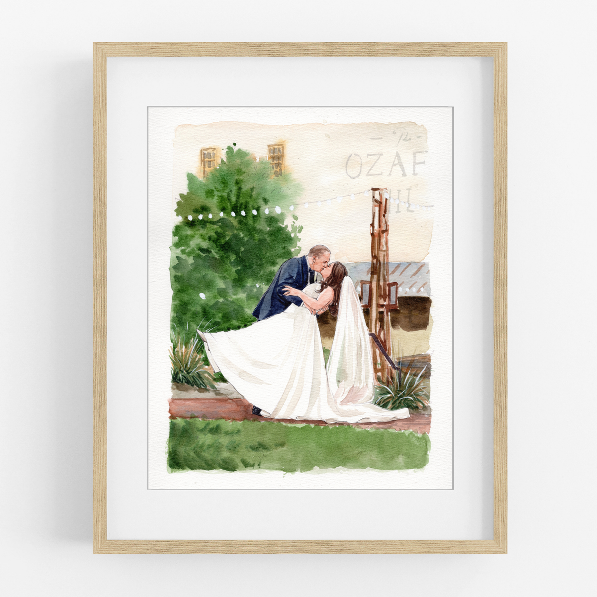 Framed watercolor portrait of a groom lifting his bride beside a garden bench and flowering trees.
