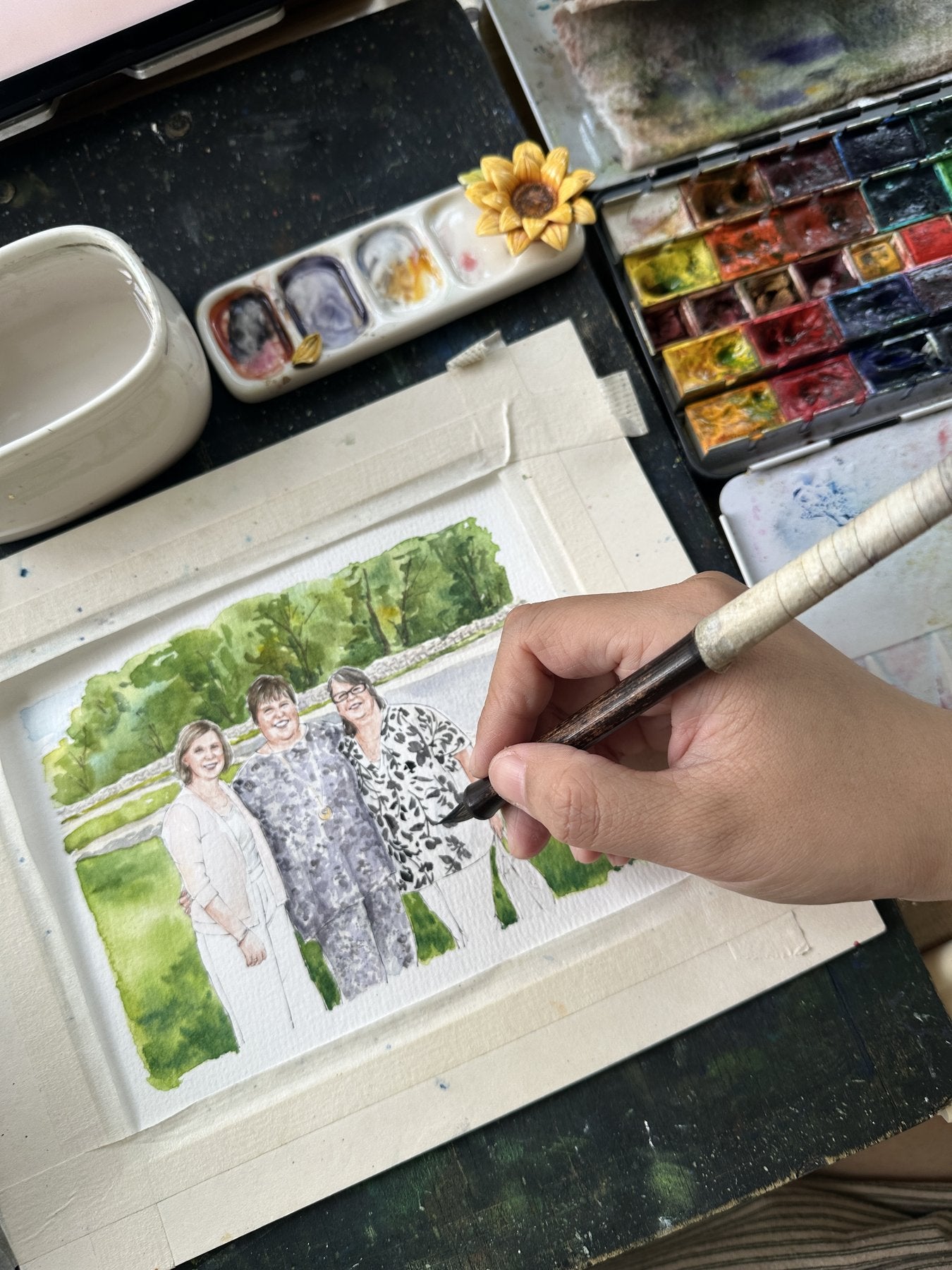 A multigenerational family watercolor portrait in progress