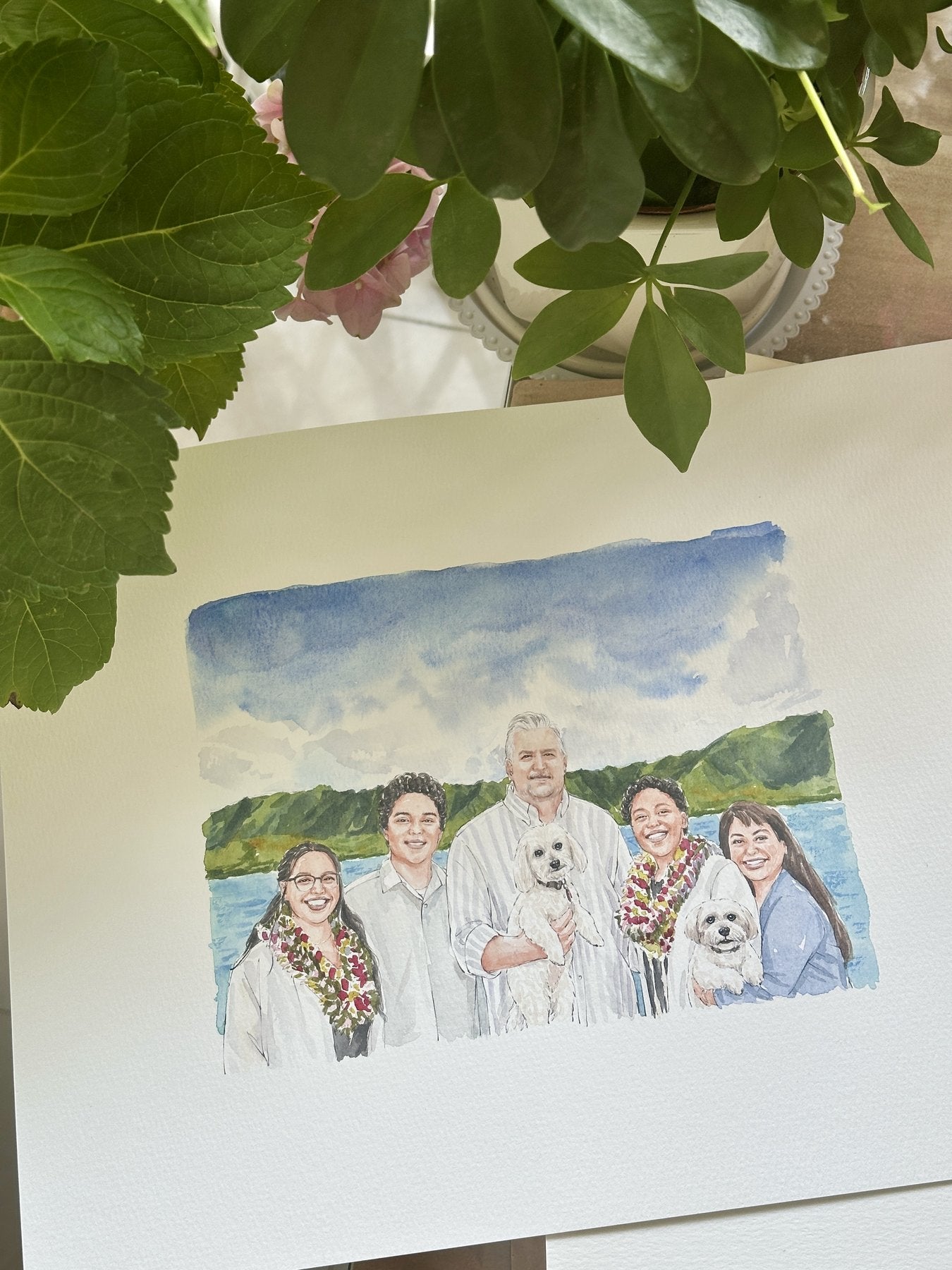 Finished watercolor portrait of a family and their pets by the ocean