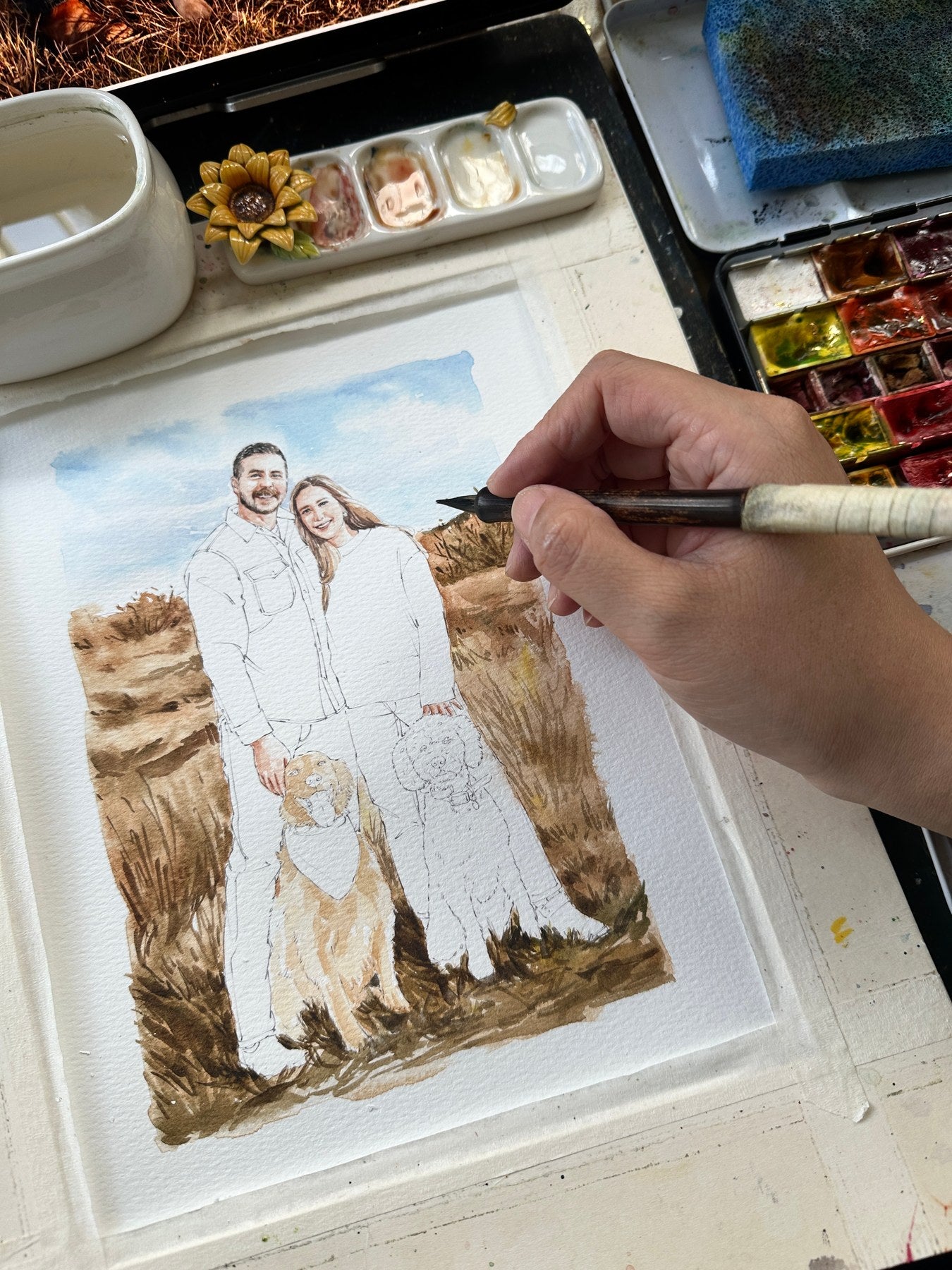 Couple and two dogs portrait being painted outdoors