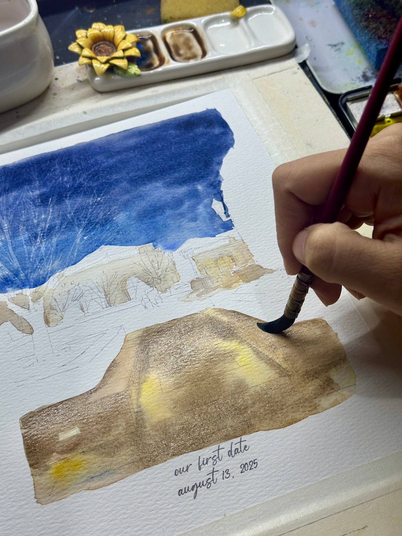 Artist hand-painting a watercolor portrait of a nighttime venue