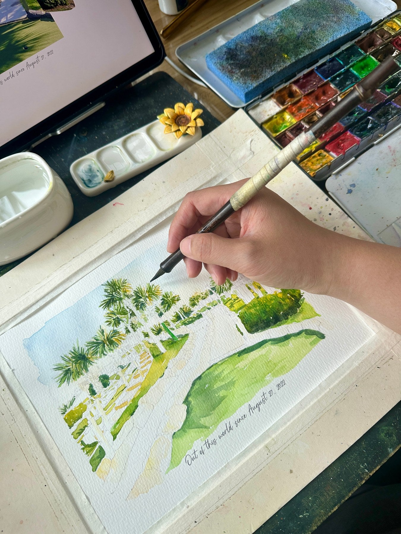 Palm-lined golf course landscape being painted in watercolor