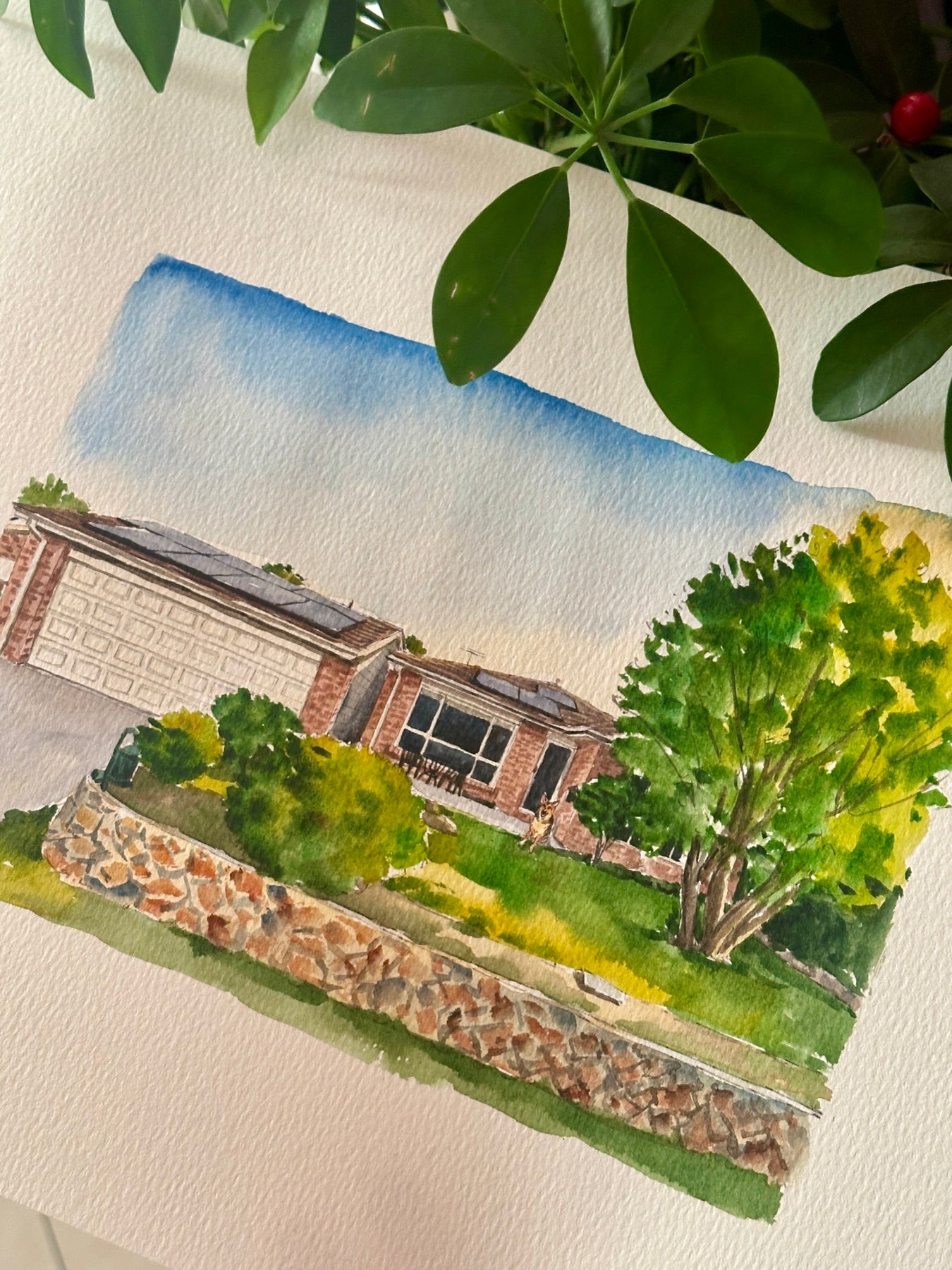 Finished hand-painted watercolor portrait of a home with a stone garden wall