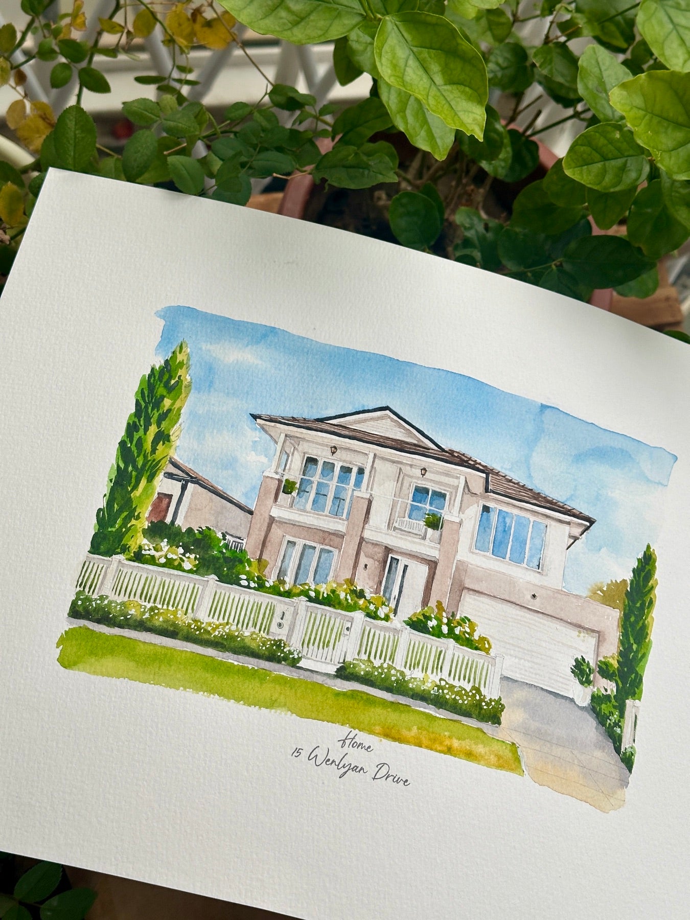 Finished hand-painted watercolor portrait of a two-story home behind a white fence