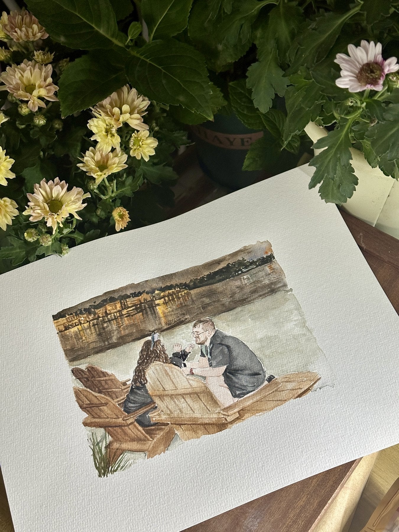 Finished watercolor portrait of a couple sharing a lakeside moment