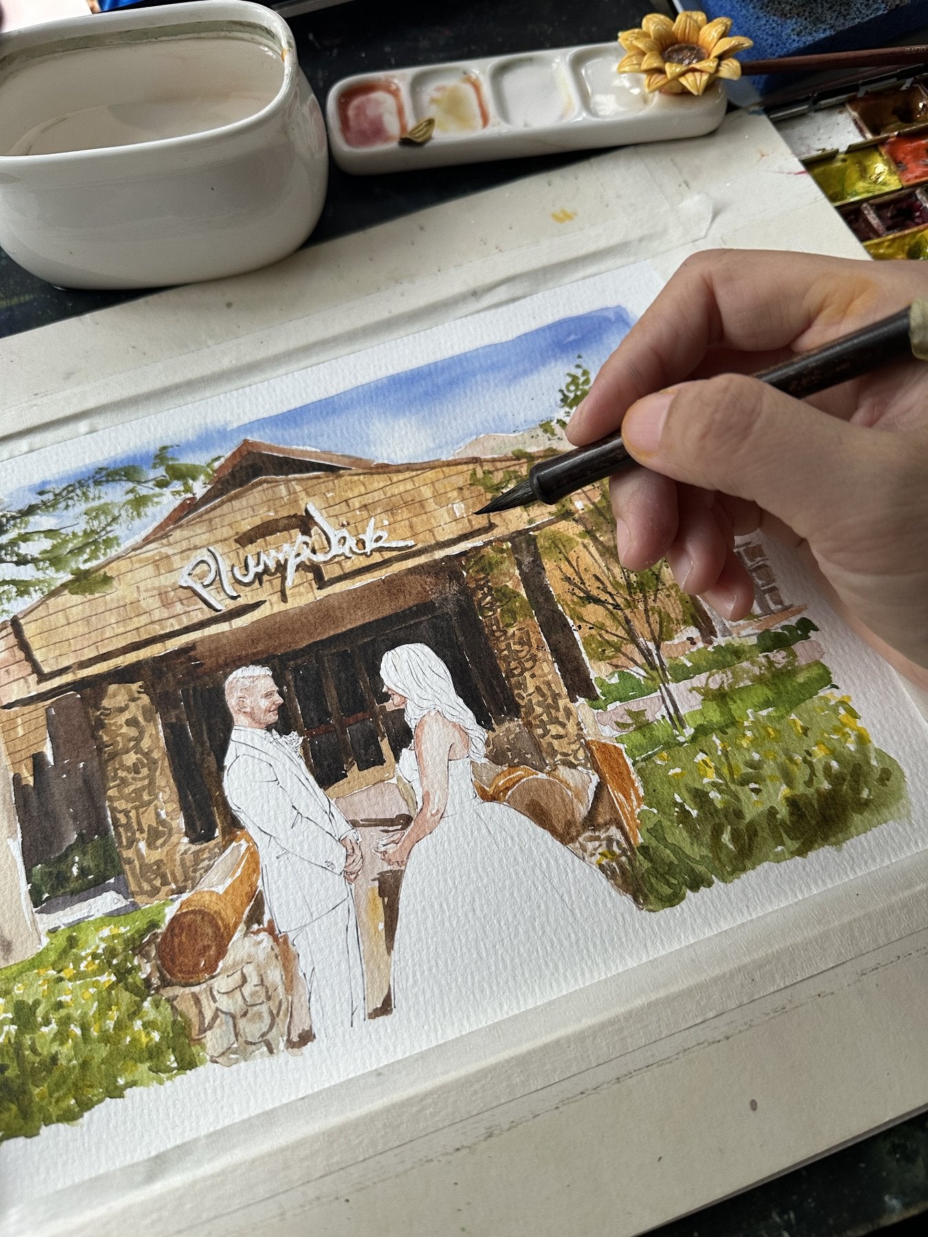 A wedding venue and couple watercolor portrait in progress