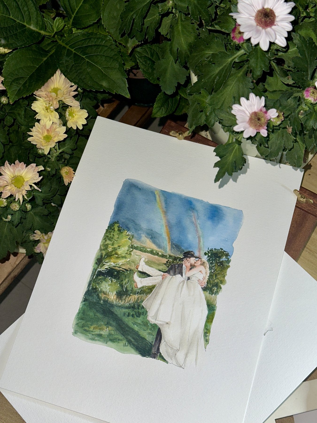 Finished watercolor wedding portrait beneath two rainbows