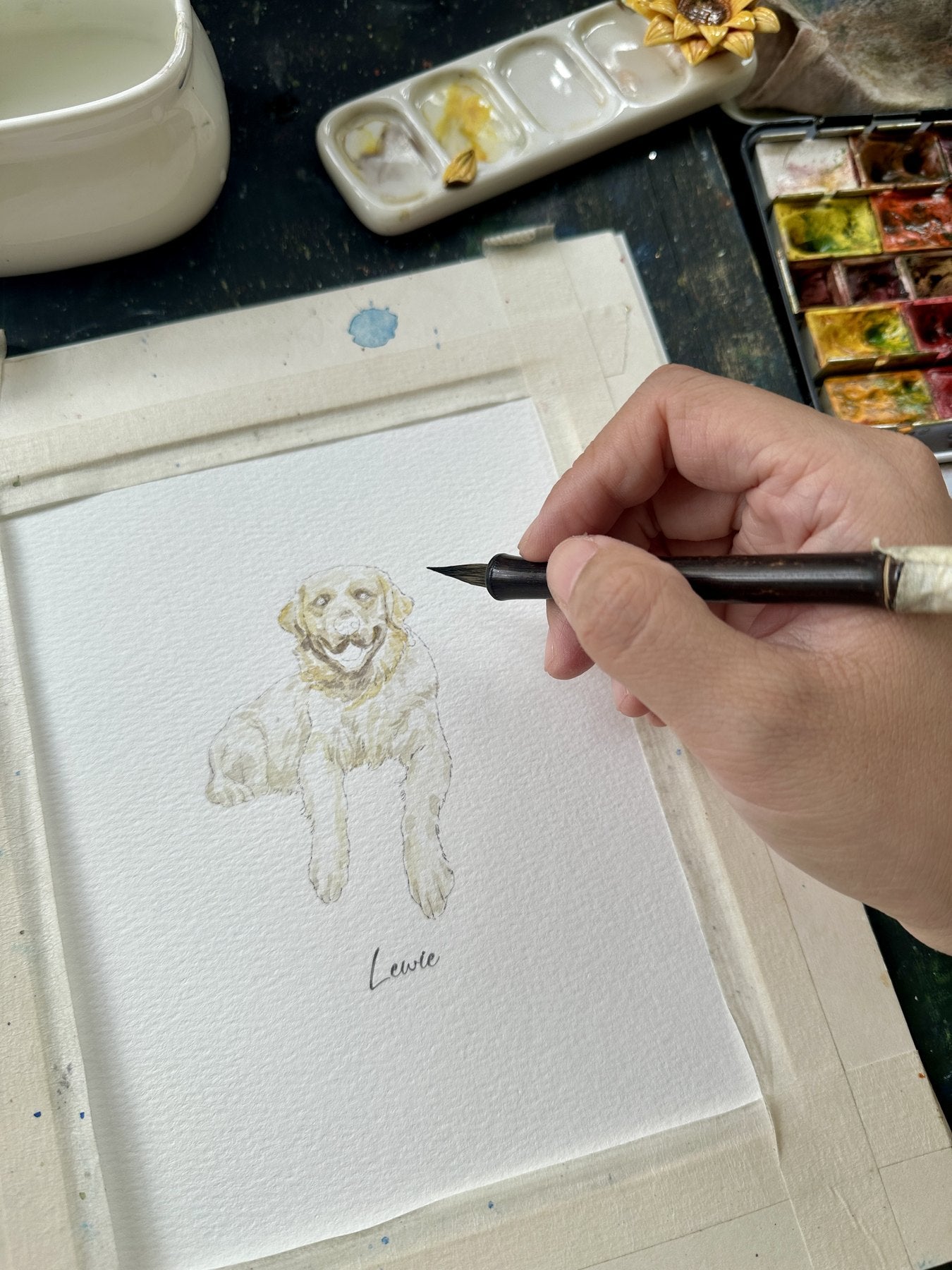 Artist painting Lewie's smiling dog portrait in watercolor